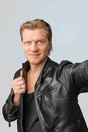 Mann in Lederjacke schaut in die Kamera 