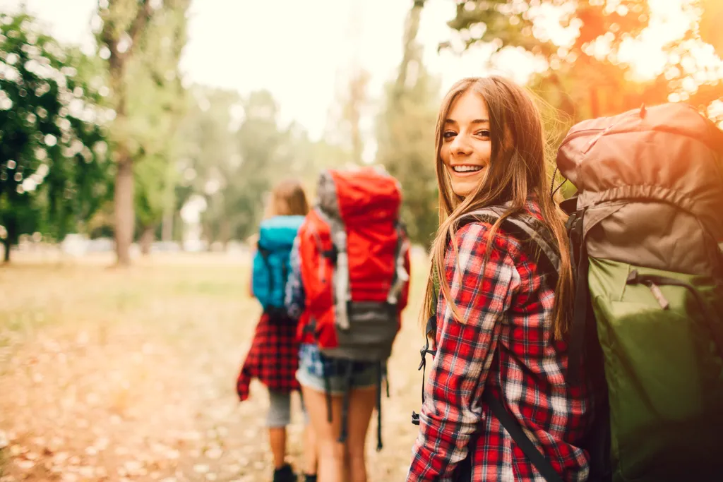 Eine junge Wandergruppe, wandernd, mit gepackten Rucksäcken im Wald.