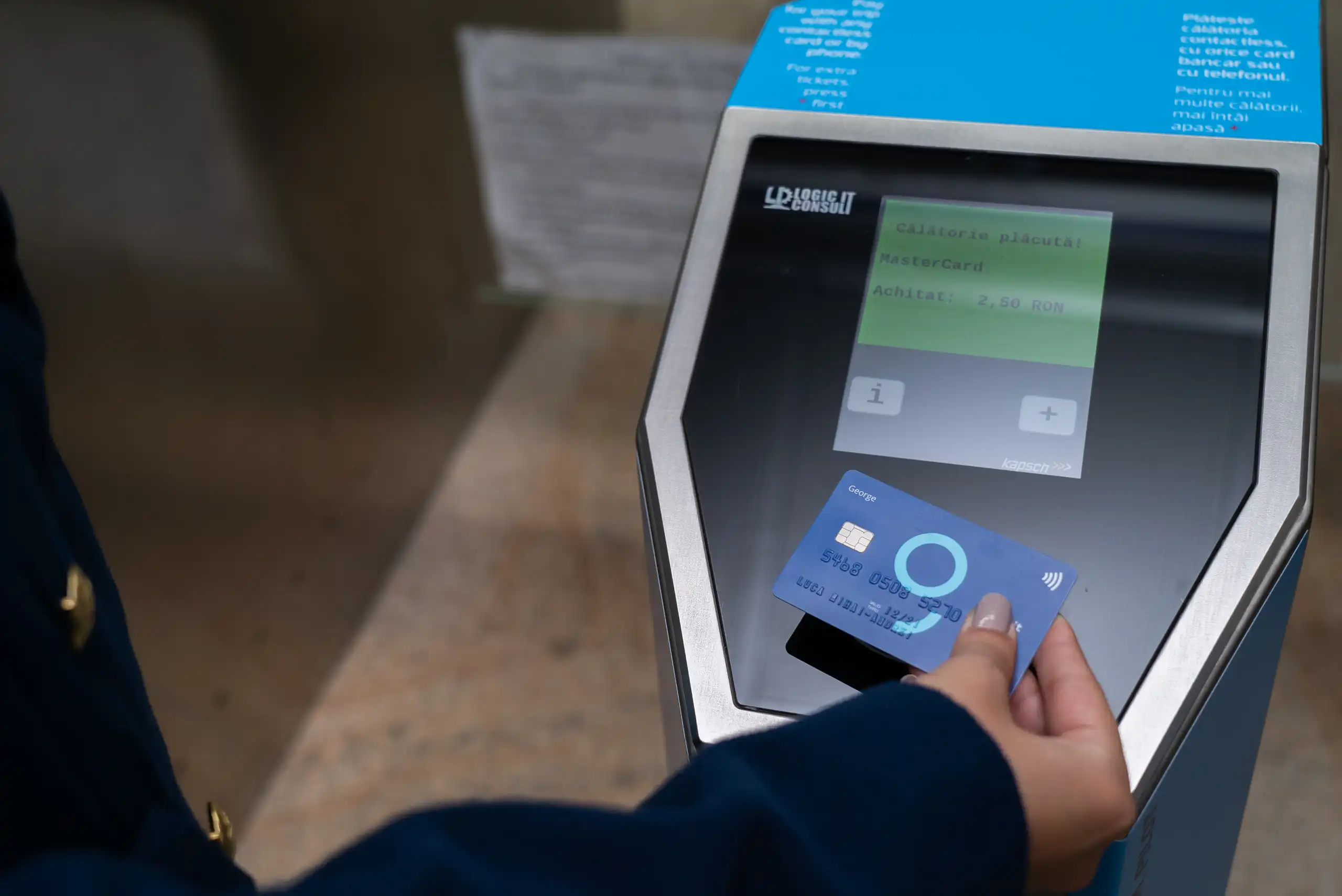 A contactless bank card held near a Bucharest metro gate reader