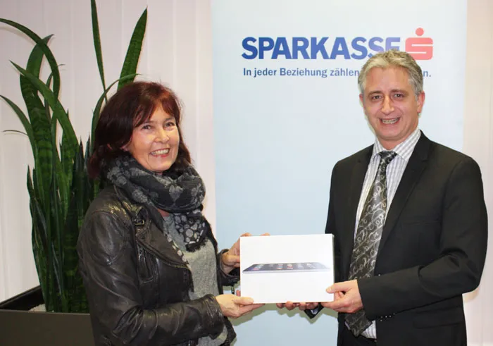 eine Frau und ein Mann halten gemeinsam ein iPad in der Hand