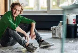 Muž sedí v místnosti před malováním
