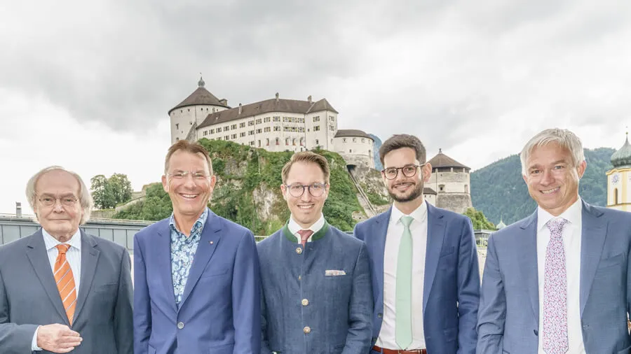 fünf Herren stehen im Freien und lächeln in die Kamera